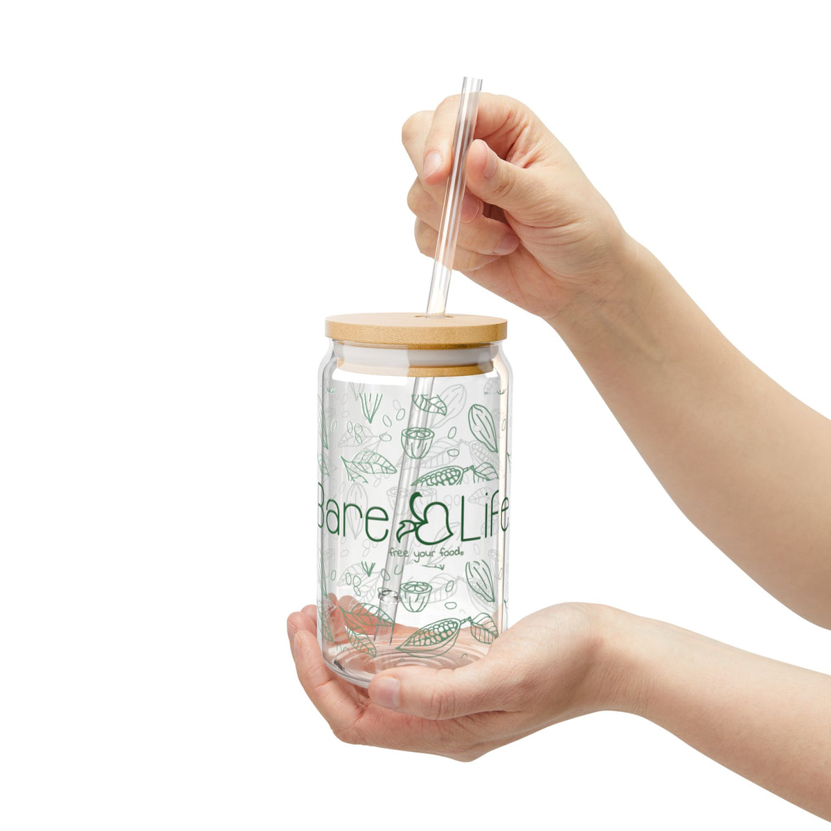 Hands holding a Bare Life Eco-Chic glass tumbler and placing the clear straw through its bamboo lid