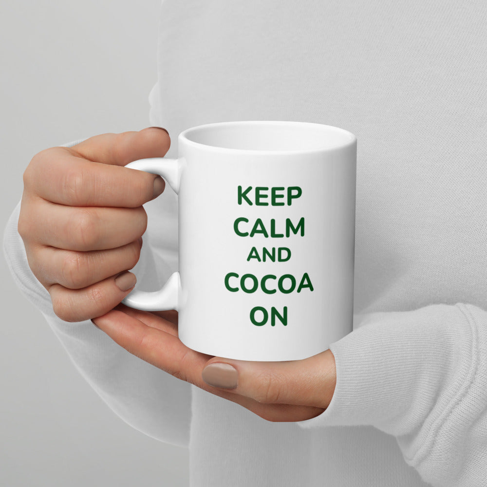 Person in a white sweater holding the Bare Life Keep Calm and Cocoa On mug in both hands