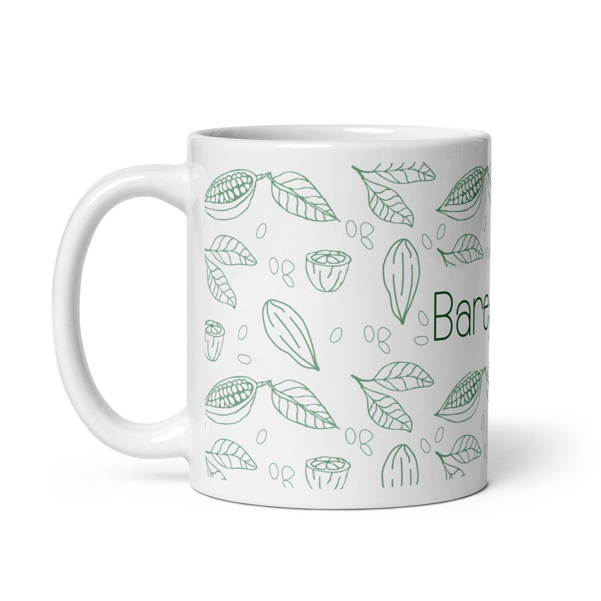 White Bare Life ceramic mug with handle on the left, showing green cocoa pods, beans, and leaves