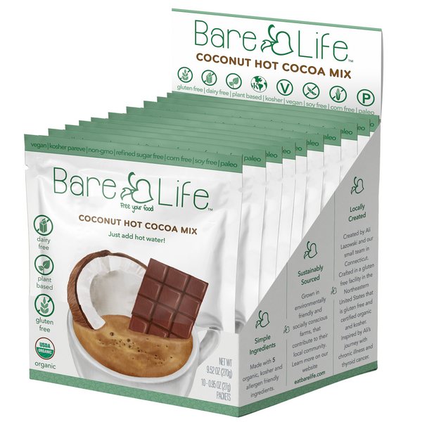 Open display box of Bare Life dairy free coconut hot cocoa mix with 10 single serving packets